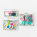 Bumkins Clear Travel Bag 3-Pack: Cacti  is neatly arranged on a white background with toys, shoes, goggles, sunglasses, & hairbrush inside.
