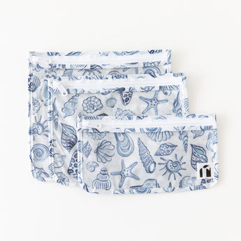 Roamio by Bumkins Clear Travel Bag 3 Pack: Shells lays overlapped on a white background.