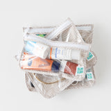 Bumkins Clear Travel Bag 3-Pack: Wander  lays stacked on a white background with toiletries inside.