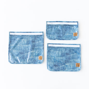 Roamio by Bumkins Clear Travel Bag 3 Pack: Crushed Denim is neatly arranged on a white background.