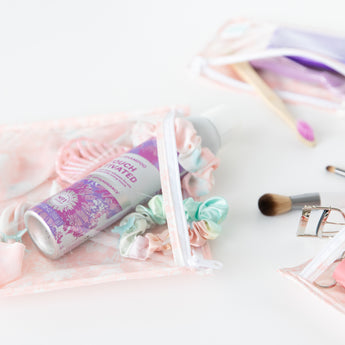 Close-up of Bumkins Clear Travel Bag 3-Pack: Lace on a white background with hair accessories and makeup inside.