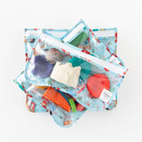 Bumkins Clear Travel Bag 3 Pack: Disney Princess Ariel is stacked on a white background, holding colorful beach-themed toys.