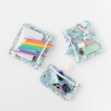 Three bags from Bumkins The Playdate Planner Deluxe 5-Piece Set: Aloha Stitch with makeup, pencils, and sunglasses inside on white.