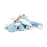 The Jellycat Sky Dragon Large lounges on a white surface, flaunting its blue plush body, white wings, and rainbow spines.