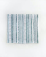 The Little Unicorn Cotton Swaddle Set, Bison features breathable cotton muslin with green and white geometric stripes. Perfect for swaddling.