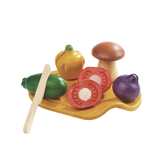 Sliceable PlanToys Assorted Vegetables Set on a board with toy knife, ideal for pretend play with veggies and mushrooms.