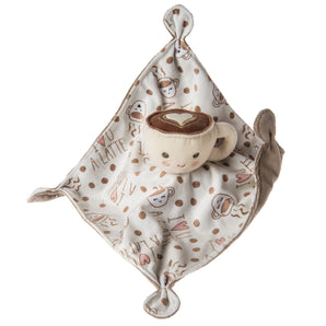 A plush coffee mug with a smile sits on the Mary Meyer Sweet Soothie Blanket, Latte, featuring coffee and heart designs.