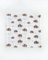 Little Unicorns Cotton Swaddle Set features white muslin with bison and green triangles, ideal for swaddling.