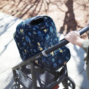 Person with a stroller using Milk Snobs Winnie the Pooh cover on a sunny day.