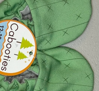 Green Cabooties Cactus Spines baby bootie with rubber soles, featuring small tree illustrations for added grip.