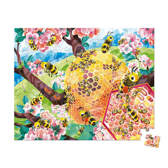 Janod Juratoys Bee Life 100 Piece Puzzle: Bees, a beehive in cherry blossoms, and lush green hills form a vibrant ecosystem.