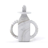 The Milk Snob Calm n Cuddle™ Cookies & Cream teether is a bottle-shaped, gray and white silicone toy with handles and texture.
