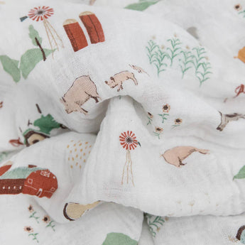 LouLou Lollipops Cotton Swaddle Set, Farmyard features white cotton muslin with barns, silos, animals, and sunflowers in green/red tones.