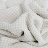 Close-up of beige and white gingham cotton from LouLou Lollipops Farmyard Swaddle Set, showing soft folds perfect for breathable blankets.