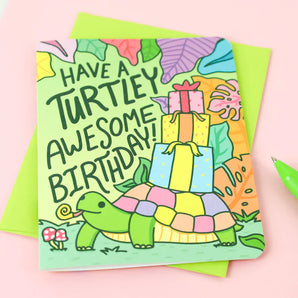 Turtle Soups Turtley Awesome birthday card features a turtle with gifts on recycled paper. Text: Have a Turtley Awesome Birthday!.