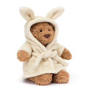 A Jellycat Bartholomew Bear, snug in a white bunny-ears bathrobe, sits cozily.