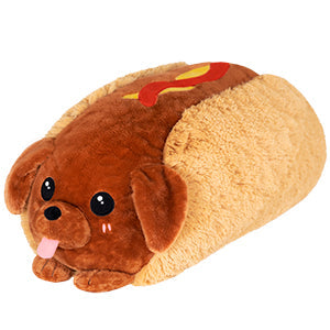 The Squishable Plush, Dachshund Hot Dog features a dachshund face, ears, and paws with a brown bun and sausage body. It has yellow and red strips resembling mustard and ketchup—ideal for cuddly snuggles!.