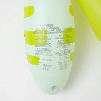 Close-up of safety warnings and batch info on Sunnylifes Monty the Monster, a lime-accented white inflatable pool noodle for kids.