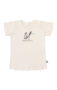 Finn and Emmas Organic Tee, First Birthday is a white baby t-shirt made from organic cotton with 1st Birthday printed in black.