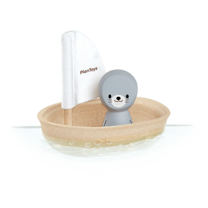 Discover the eco-friendly PlanToys Sailing Boat, Seal: a sustainable toy with PlanWood, featuring a gray seal figure and white sail.