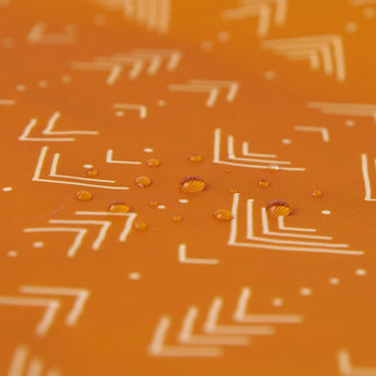 Close-up of water droplets on an orange Bumkins Reusable Snack Bag, Small 2-Pack: Sunshine and Grounded.