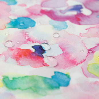 Water droplets dance on watercolor patterns blending pink, blue, green, and yellow on Bumkins Clear Travel Bag 3-Pack: Watercolor.