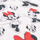 Bumkins Junior Bib features Minnie Mouse with red bows on a stain-resistant, easy-wipe fabric, against water droplets on white.