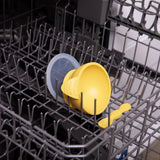 A Bumkins Silicone First Feeding Set in Pineapple, featuring a yellow helmet and suction bowl, fits snugly in the dishwasher.