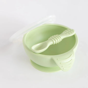 Bumkins Silicone First Feeding Set: Sage includes a suction base bowl, matching spoon, and translucent lid on a white background.
