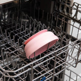 Bumkins Silicone Grip Bowl: Pink sits in the top rack of an open dishwasher.
