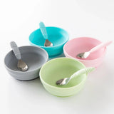 Four bowls with spoons, including Bumkins Silicone Grip Bowl: Sage, are arranged neatly on a white background.
