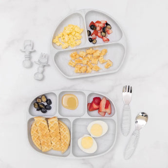 Two Silicone Grip Dish with Lid by Bumkins show toddler portions: eggs, berries, waffles, syrup on a marble surface.