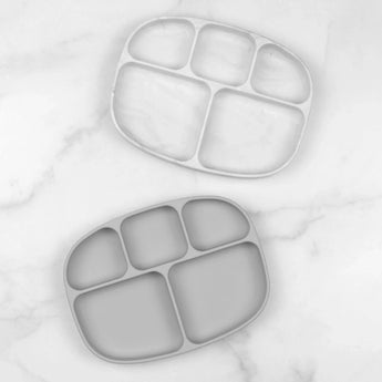 Two gray Bumkins Silicone Grip Dishes with lids (5 sections), made of food-safe silicone, on a white marble surface.