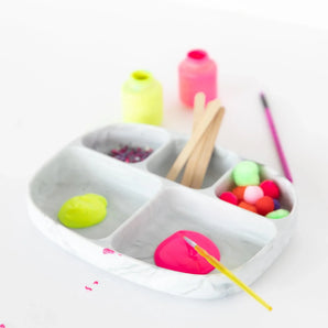 Bumkins Silicone Grip Dish with Lid (5 Section): Marble keeps neon paints, pom-poms, glitter, and wood sticks tidy on a white background.