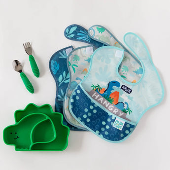 3 dinosaur-themed bibs, a dinosaur shaped plate, and utensils from Bumkins Ultimate Gift Set - Dinosaurs & Blue Tropic on a white background.