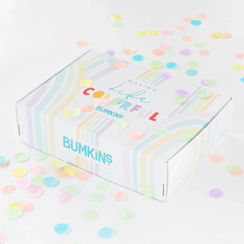 A colorful gift box for Bumkins Ultimate Gift Set - Dinosaurs & Blue Tropic surrounded by confetti on a white background.
