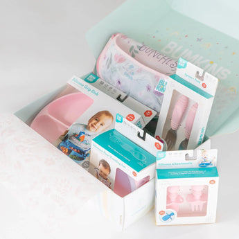 Ultimate Gift Set - Floral & Lace by Bumkins: Pink silicone feeding items include a Grip Dish, Chewtensils, and teething set with smiling baby on box.