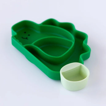 A green Bumkins Silicone Little Dipper Round 3-Pack: Gumdrop is attached to a dinosaur-shaped plate on a white background.