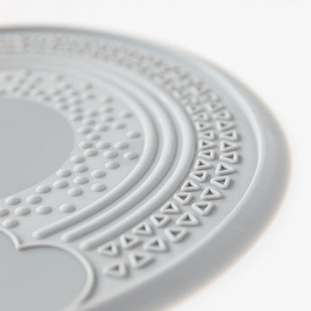 Close-up of Bumkins Silicone Sensory Placemat: Gray on a white background, featuring textured dots and triangles on a nonslip surface.