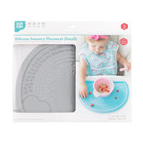 Bumkins Silicone Sensory Placemat: Gray is shown in a packaging box with a photo of a child and a front window partially showing the placemat.