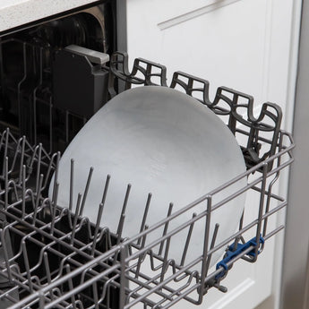 Bumkins Silicone Sensory Placemat: Marble sits in the top rack of an open dishwasher.