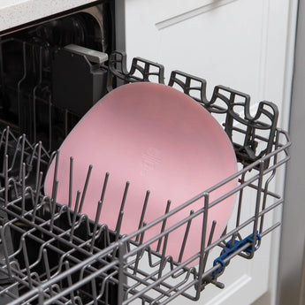 Bumkins Silicone Sensory Placemat: Pink sits in the top rack of an open dishwasher.