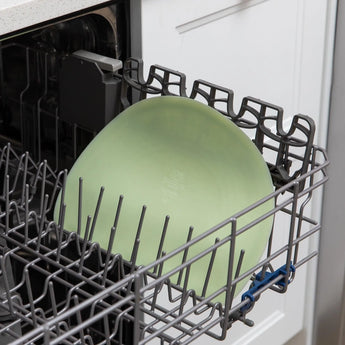 Bumkins Silicone Sensory Placemat: Sage sits in the top rack of an open dishwasher.