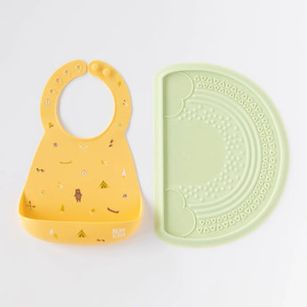 Bumkins Silicone Sensory Placemat: Sage sits next to a yellow silicone bib on a white background.