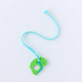 A Bumkins Silicone Accessory Tether 2-Pack: Blue attached to a dinosaur-shaped teether on a white background.