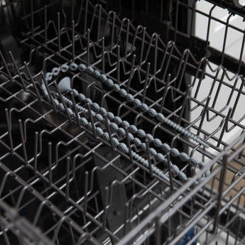 Bumkins Silicone Accessory Tether 2-Pack: Gray sits in the top rack of an open dishwasher.