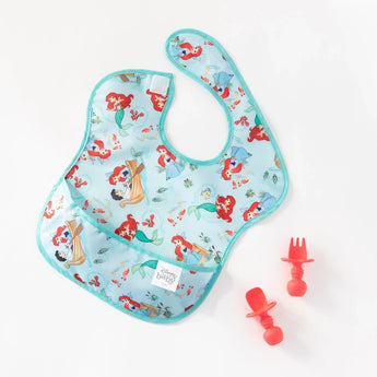 Blue baby bib with a mermaid print and Bumkins red Silicone Chewtensils®, set on a plain background.