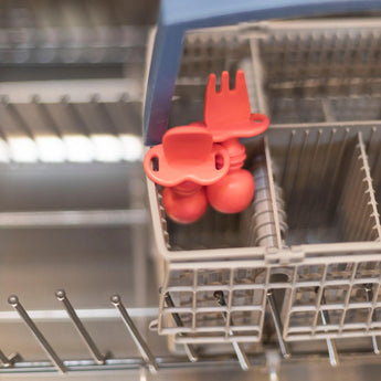 Bumkins Silicone Chewtensils® in red feature sensory bumps and sit in a dishwasher basket—ideal for baby-led weaning.