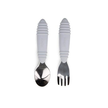The Bumkins Spoon + Fork: Gray, a silicone toddler utensil set with ergonomic handles, rests on a white background.