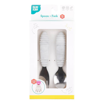 The Bumkins Spoon + Fork: Marble set for toddlers features self-feeding tools with white handles in a white and teal box.